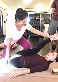 Un professeur de yoga apprend des étirements de compression avancés pour améliorer l'amplitude des mouvements de l'articulation de la hanche