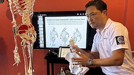 脊椎模型と画像教材で関節の位置と動きを説明する池田講師